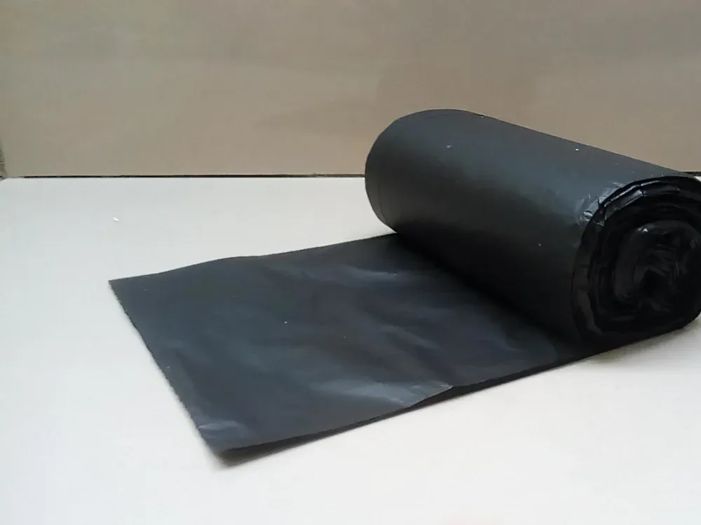 A roll of heavy black refuse sacks, partly unrolled
