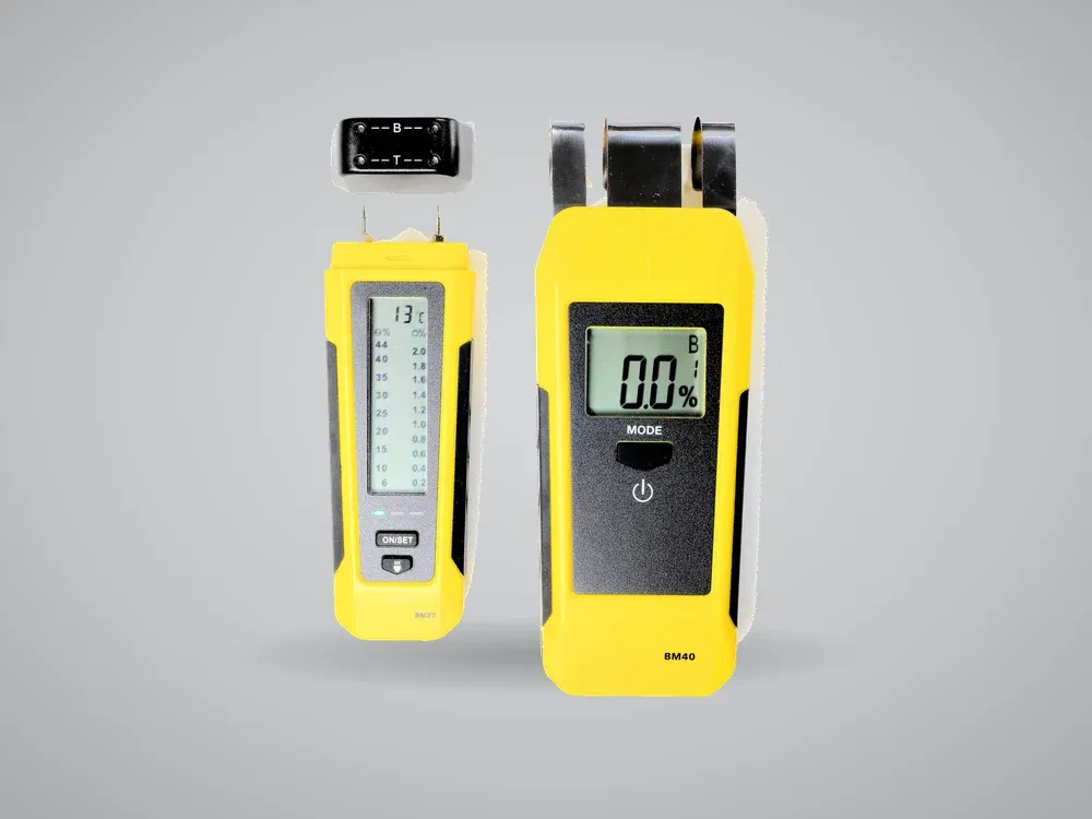 Two handheld pin-type moisture meters with digital displays