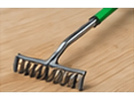 An insulation rake — a wide-headed rake with a green handle for levelling loose fill