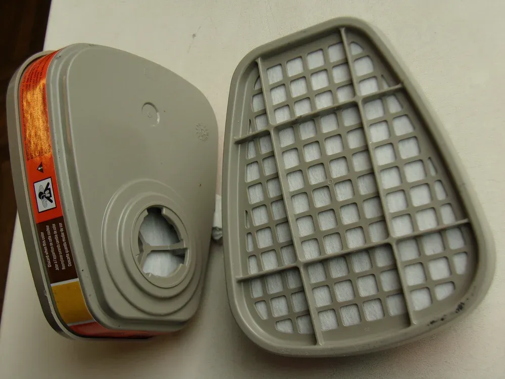 A pair of respirator filter cartridges, front and back
